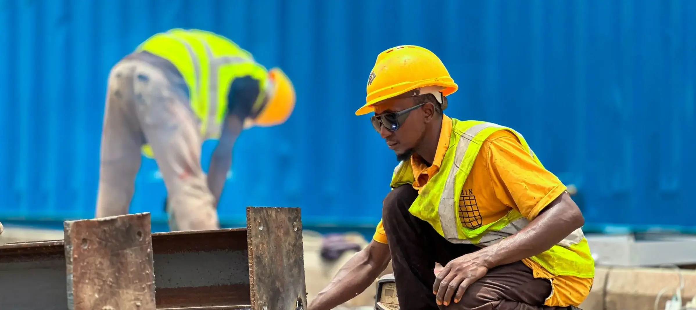 Xtetix crew in hard hats and high-visibility vests working on steel beams on site
